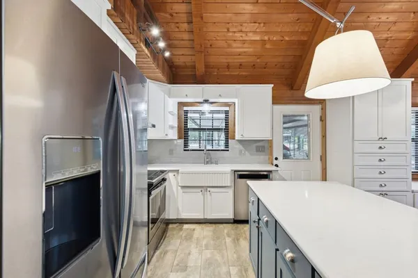 a kitchen with a sink a refrigerator and cabinets