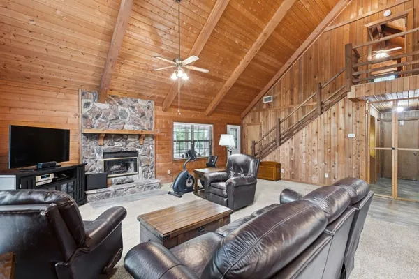 a living room with furniture a fireplace and a flat screen tv