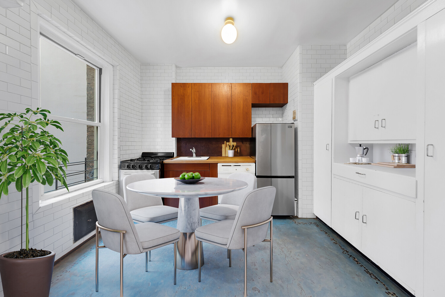 261 West 22nd Street, Unit 11 Manhattan, NY 10011 - Photo 2 of 10 a kitchen with stainless steel appliances a dining table chairs and a refrigerator