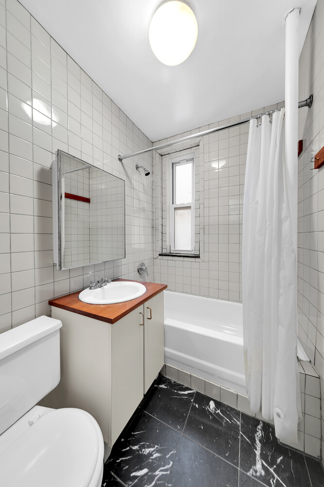 261 West 22nd Street, Unit 11 Manhattan, NY 10011 - Photo 4 of 10 a bathroom with a sink toilet and shower