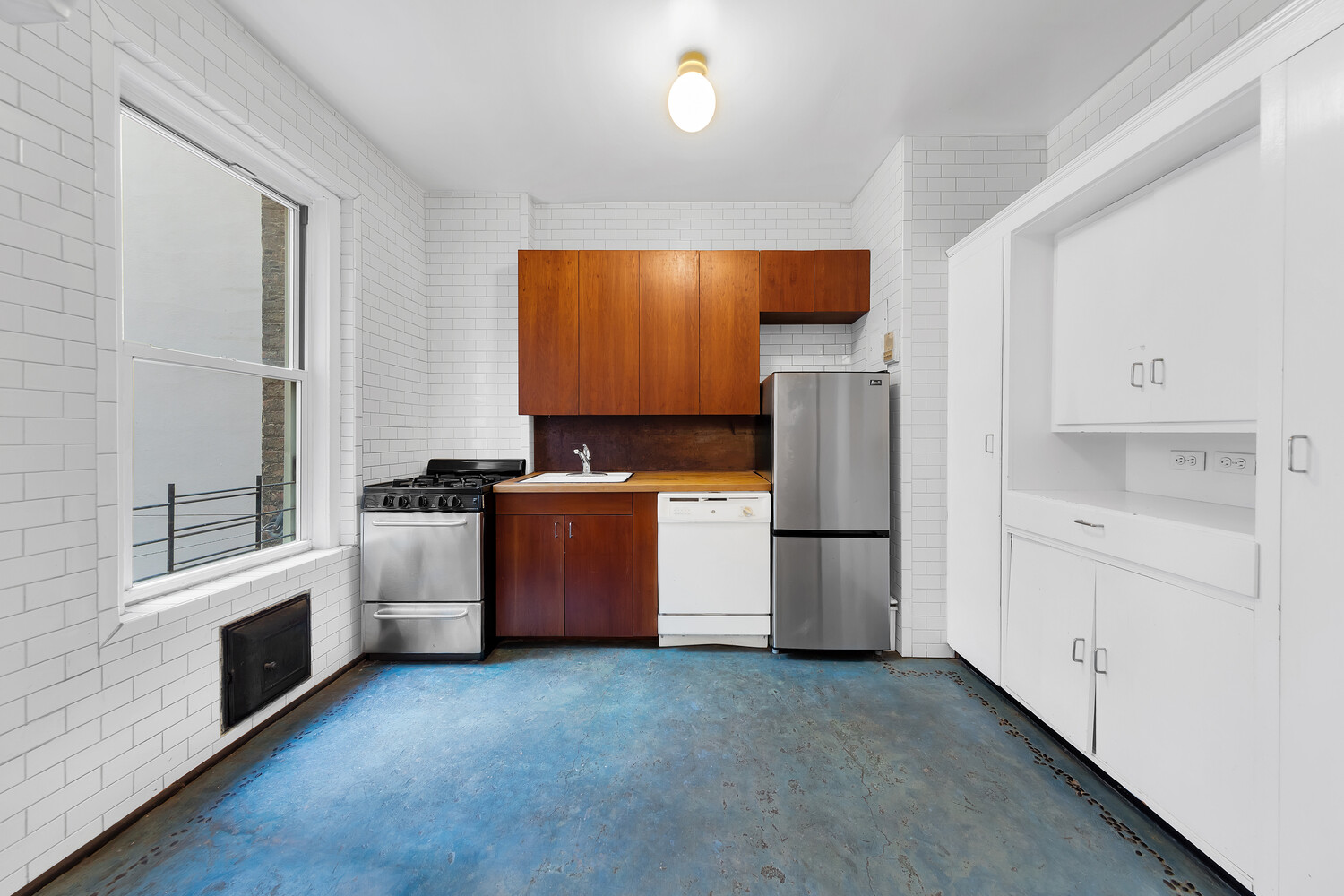 261 West 22nd Street, Unit 11 Manhattan, NY 10011 - Photo 7 of 10 a kitchen with a refrigerator sink and stove