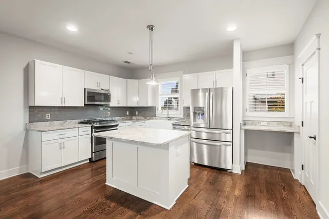 a kitchen with stainless steel appliances a refrigerator sink and microwave