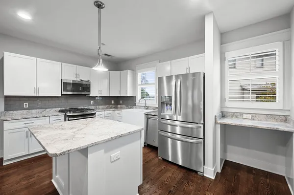 a kitchen with stainless steel appliances a refrigerator and a stove top oven