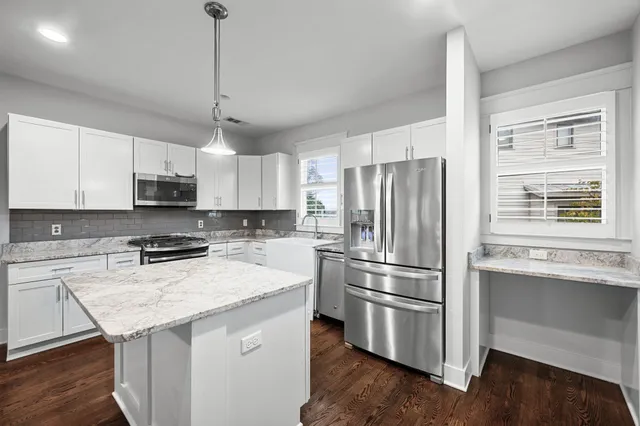 a kitchen with stainless steel appliances a refrigerator and a stove top oven