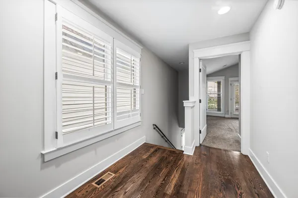 a view of a room with wooden floor and a window