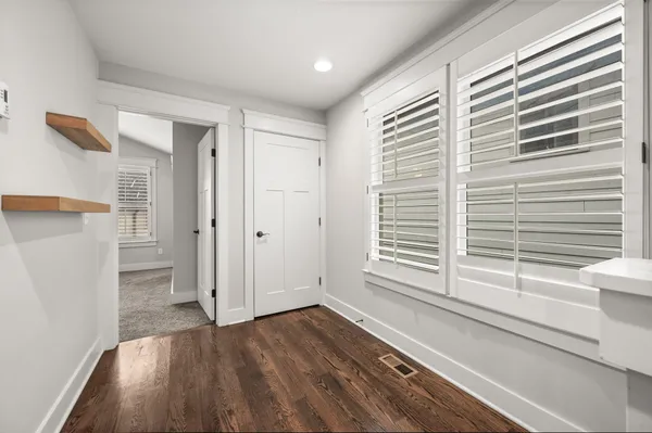a view of a hallway with wooden floor and a cabinet