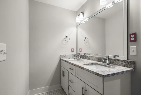 a bathroom with a granite countertop bathtub a sink and a large mirror