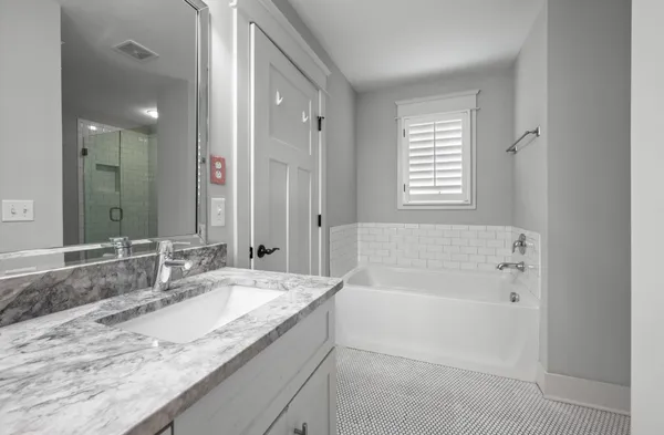 a white bath tub sitting next to a shower