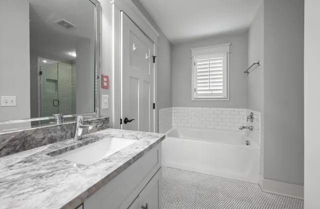 a white bath tub sitting next to a shower