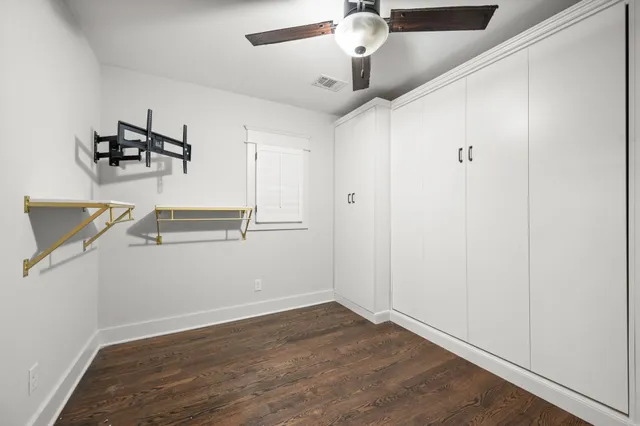 a room with gym equipment and wooden floor