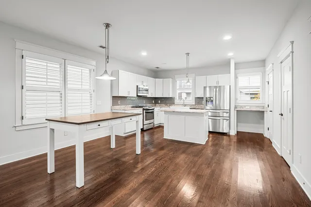 a kitchen with wooden floors and white cabinets