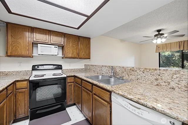 a kitchen with granite countertop wood cabinets and a stove top oven
