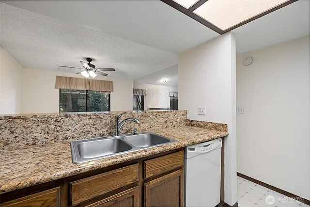 a kitchen with stainless steel appliances granite countertop a sink and cabinets with wooden floor