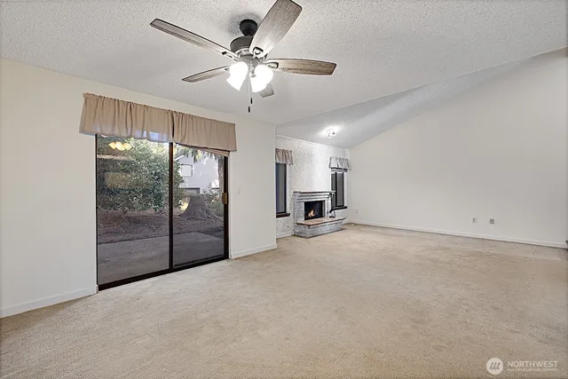a view of an empty room with a chandelier fan