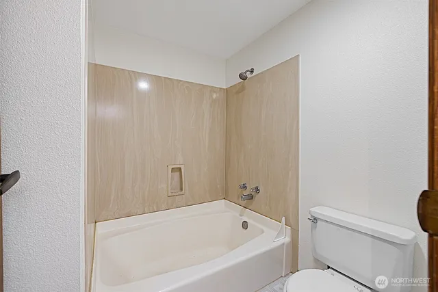 an empty room with a window and a ceiling fan