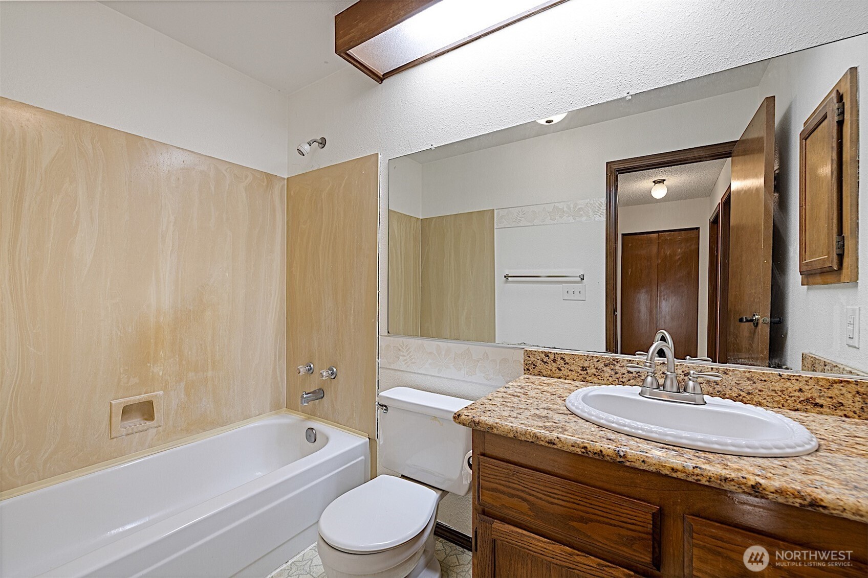 4724 Southwest 317th Lane, Unit B Federal Way, WA 98023 - Photo 30 of 40 a bathroom with a granite countertop sink a toilet a mirror and bathtub