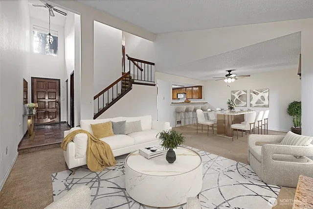 a view of an empty room with stairs and a ceiling fan