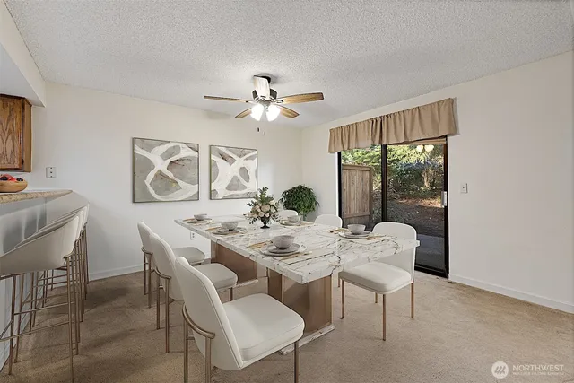 an empty room with chandelier fan and windows
