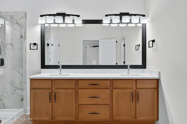 a bathroom with a double vanity sink toilet and a mirror