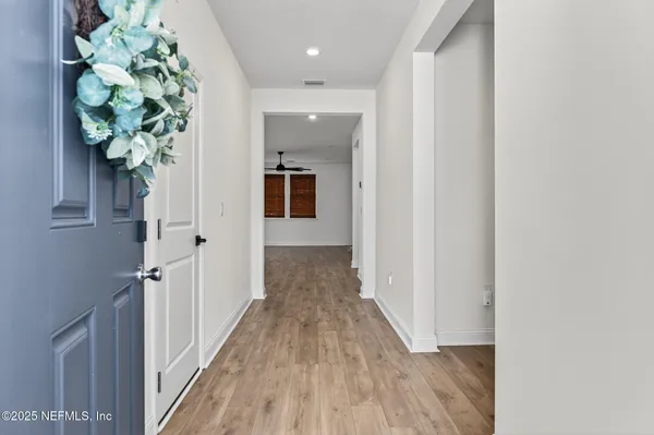 a large kitchen with stainless steel appliances granite countertop a large counter top a wooden floors and a large window