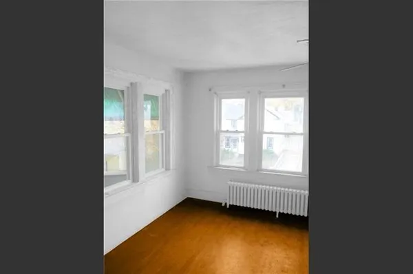a view of a bedroom with wooden floor and closet