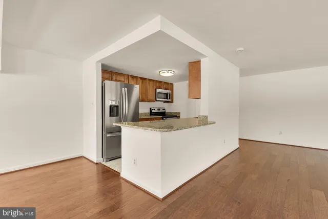 a living room with stainless steel appliances kitchen island a sink a stove and a microwave oven on the counter