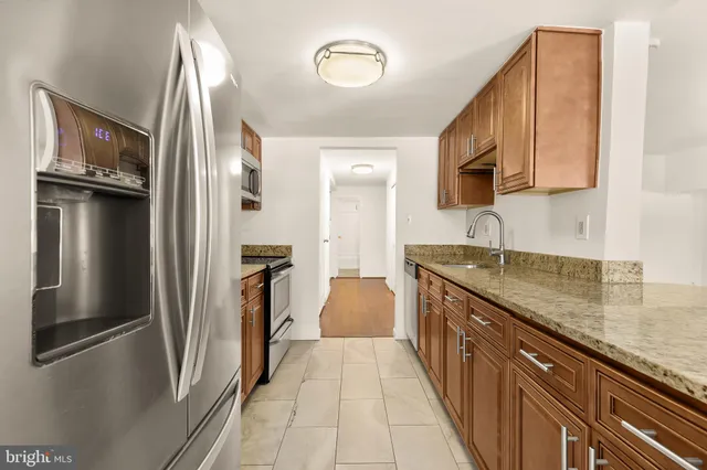 a kitchen with stainless steel appliances granite countertop a refrigerator and a sink