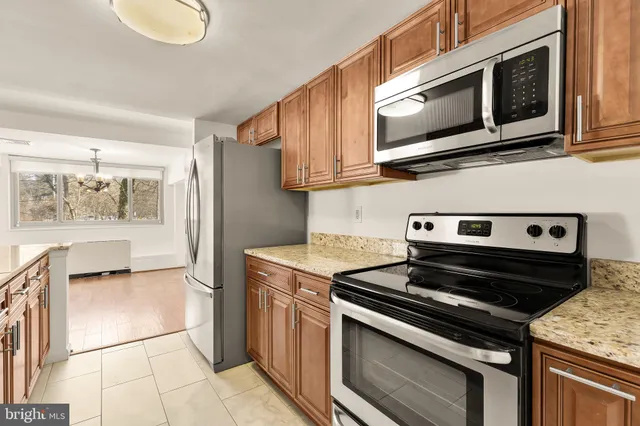 a kitchen with stainless steel appliances granite countertop a stove microwave and refrigerator