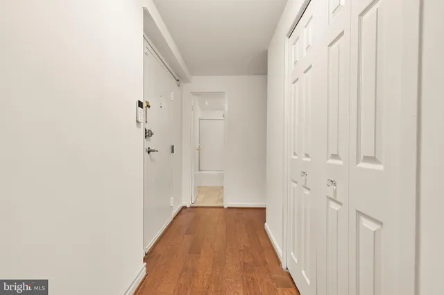 a view of a hallway with wooden floor and entryway
