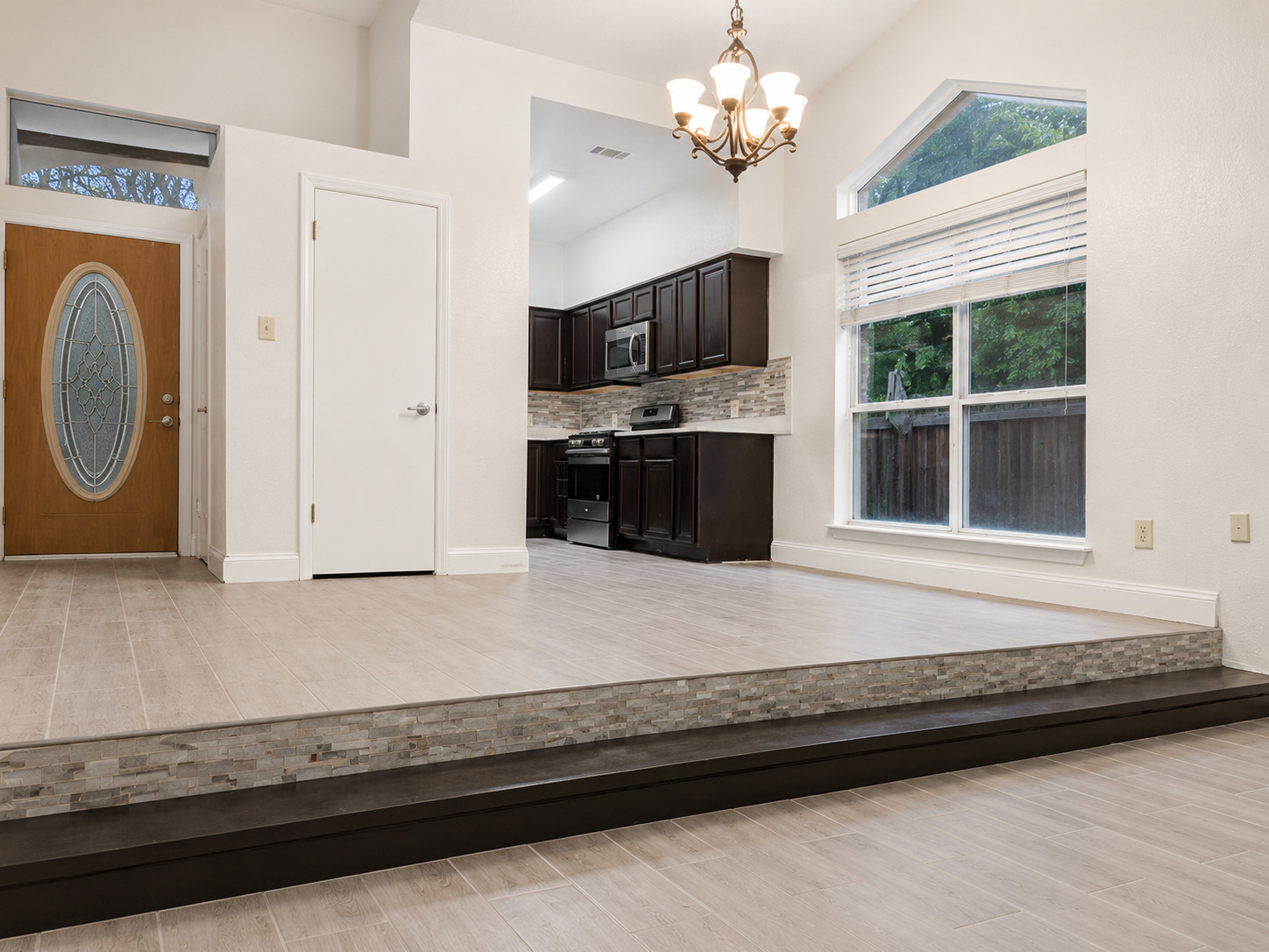 5611 Meadow Crest Austin, TX 78744 - Photo 9 of 29 Natural light floods this inviting living area, showcasing its soaring ceilings and elegant tiled flooring.