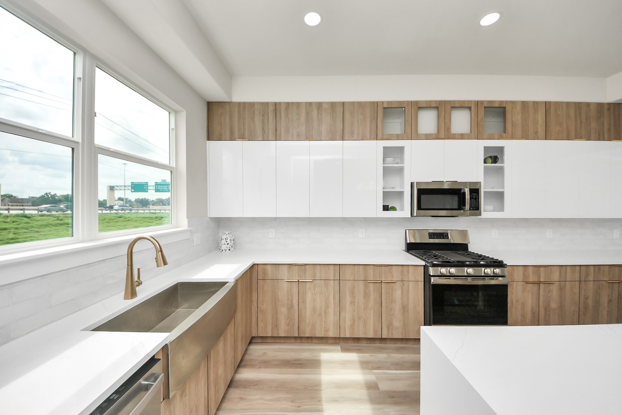 2014 Blodgett Street Houston, TX 77004 - Photo 15 of 49 a kitchen with stainless steel appliances a sink a stove a microwave and white cabinets