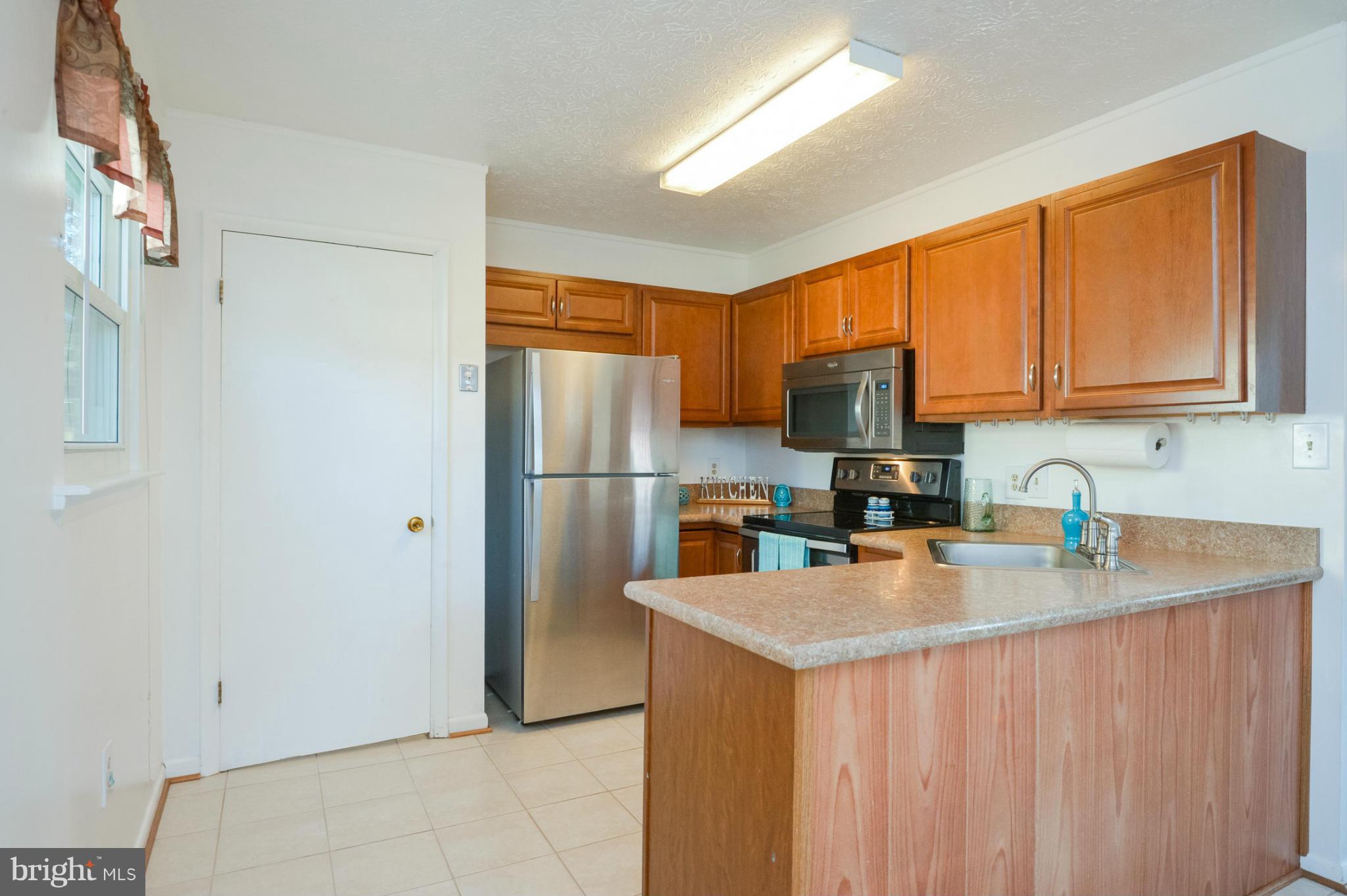1927 Grant Road Halethorpe, MD 21227 - Photo 6 of 29 a kitchen with stainless steel appliances granite countertop a refrigerator stove top oven a sink and dishwasher