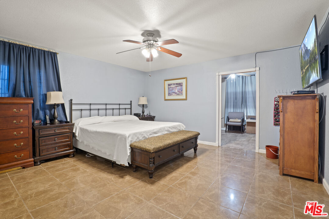 10647 East Ave R 10 Littlerock, CA 93543 - Photo 14 of 34 a spacious bedroom with a bed and a flat screen tv