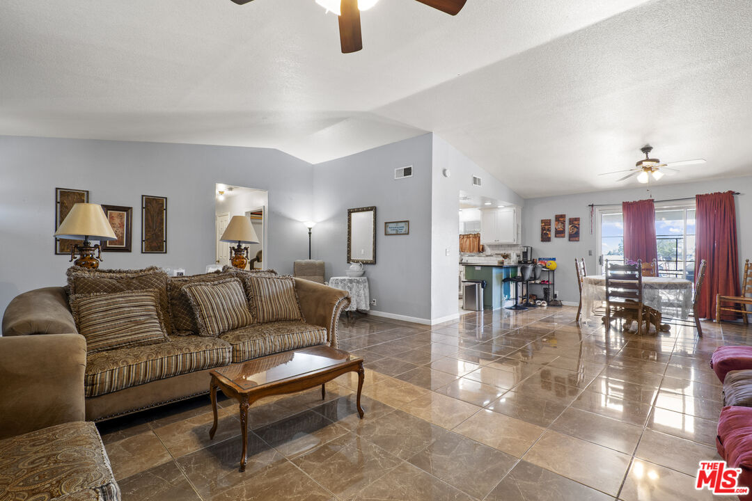 10647 East Ave R 10 Littlerock, CA 93543 - Photo 23 of 34 a living room with furniture a dining table and a chandelier