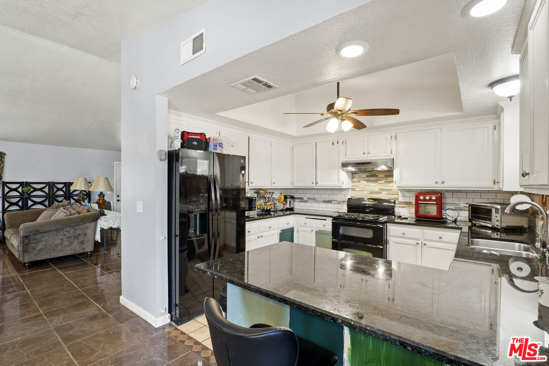 10647 East Ave R 10 Littlerock, CA 93543 - Photo 29 of 34 a kitchen with kitchen island a large counter top space appliances and cabinets