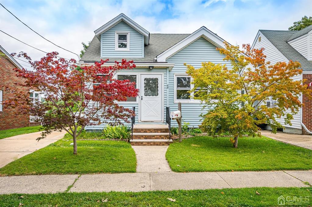 a front view of a house with a yard and trees