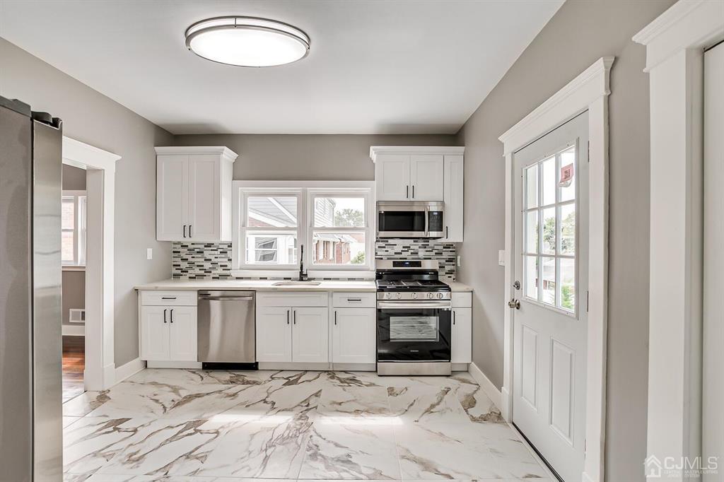 48 Johnson Place South River, NJ 08882 - Photo 17 of 34 a kitchen with stainless steel appliances granite countertop a stove a sink and a refrigerator