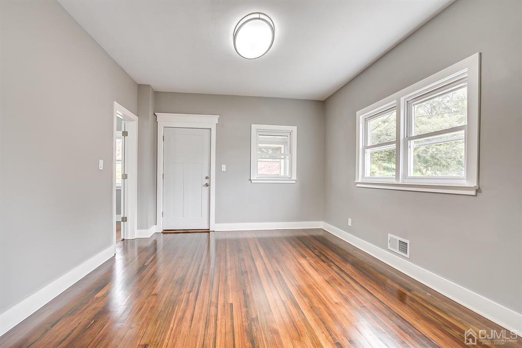 48 Johnson Place South River, NJ 08882 - Photo 8 of 34 an empty room with wooden floor and windows