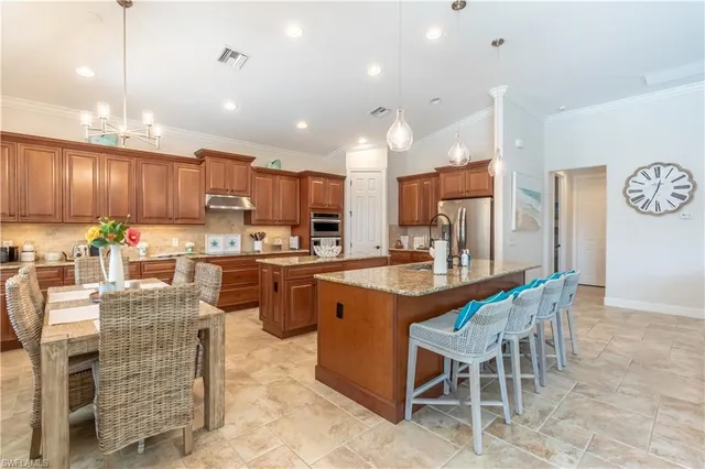 a kitchen with kitchen island granite countertop wooden cabinets a center island stainless steel appliances and dining table