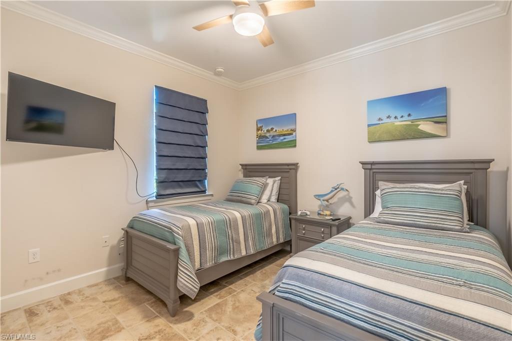9332 Fieldstone Lane Naples, FL 34120 - Photo 19 of 41 a bedroom with two beds and a chandelier