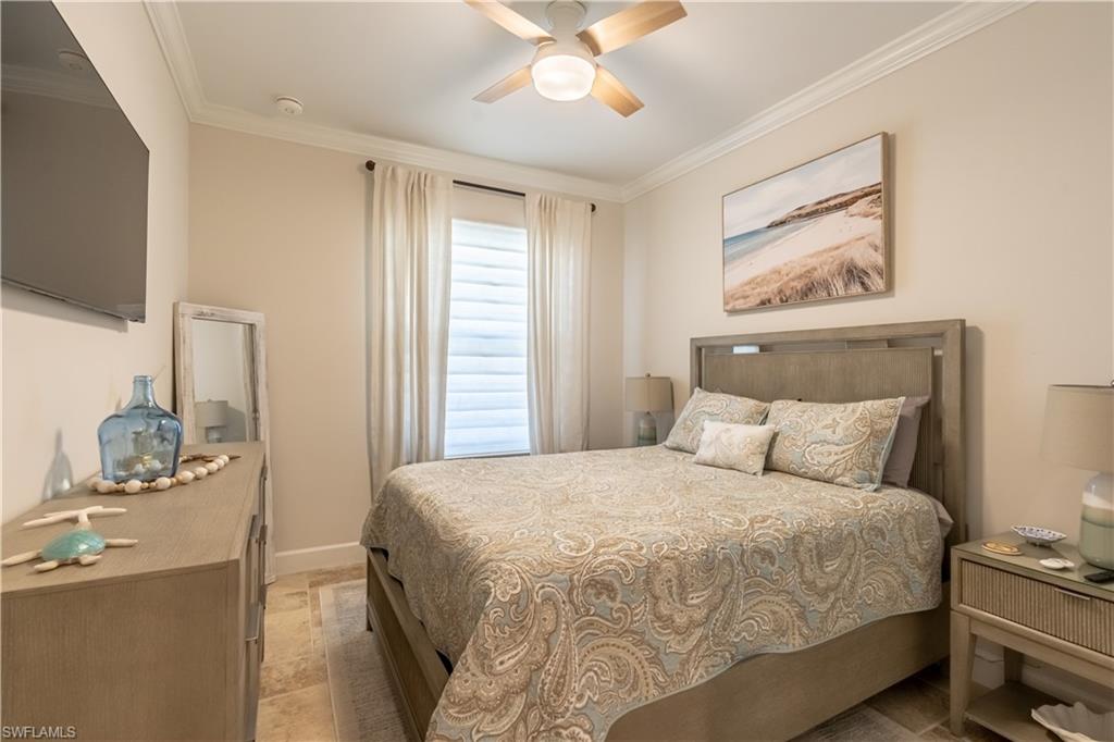 9332 Fieldstone Lane Naples, FL 34120 - Photo 21 of 41 a bedroom with a bed and a flat tv screen on dresser
