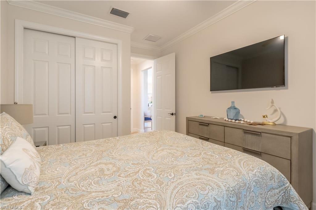 9332 Fieldstone Lane Naples, FL 34120 - Photo 22 of 41 a bedroom with a bed and a flat screen tv