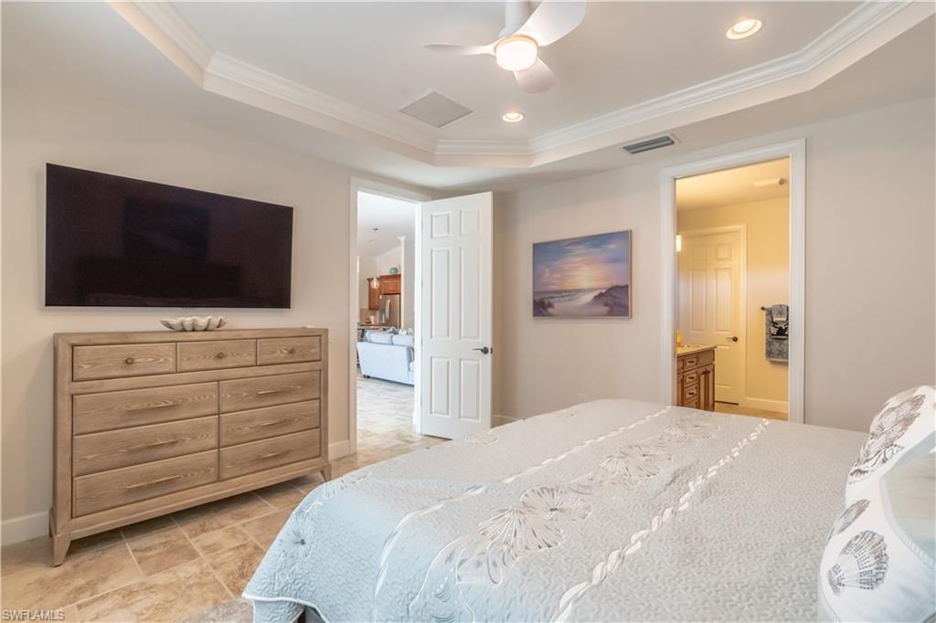 9332 Fieldstone Lane Naples, FL 34120 - Photo 25 of 41 a bedroom with a bed and a flat screen tv