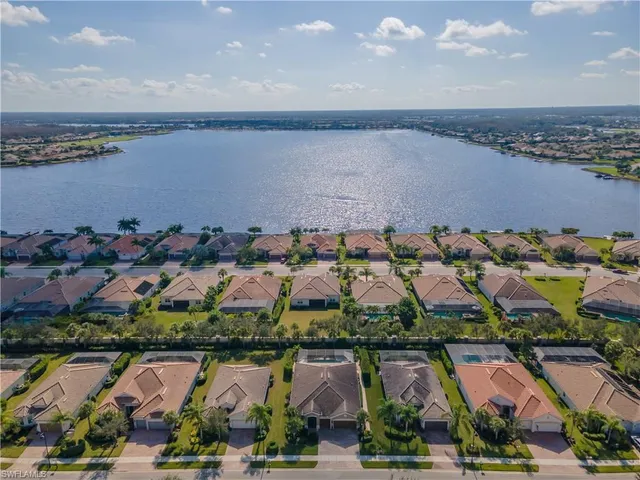 an aerial view of lake and residential houses with outdoor space