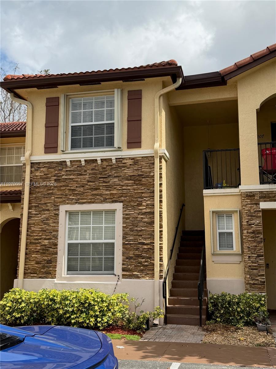 1485 Northeast 33rd Road, Unit 207 Homestead, FL 33033 - Photo 1 of 10 a front view of a house with a yard and garage