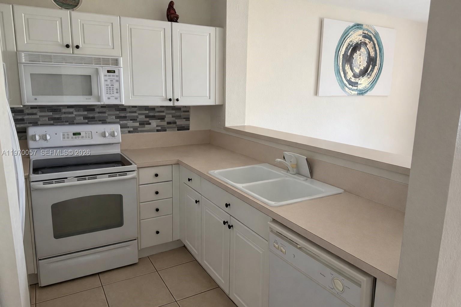 1485 Northeast 33rd Road, Unit 207 Homestead, FL 33033 - Photo 3 of 10 a kitchen with granite countertop white cabinets white stainless steel appliances and a sink