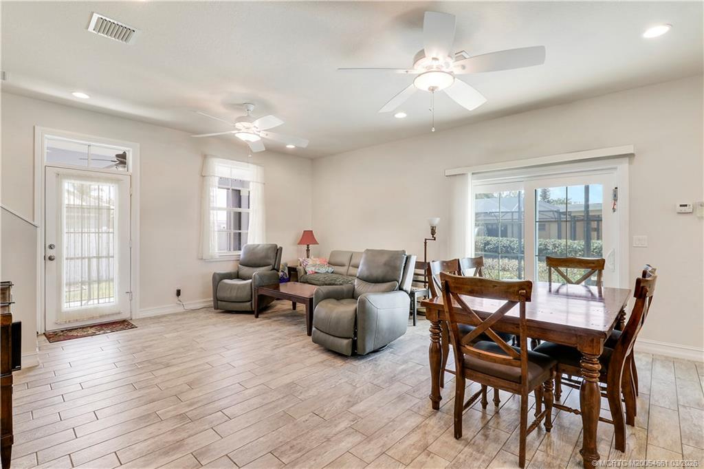5352 Southeast Nassau Terrace Stuart, FL 34997 - Photo 22 of 53 a living room with furniture a chandelier and a dining table