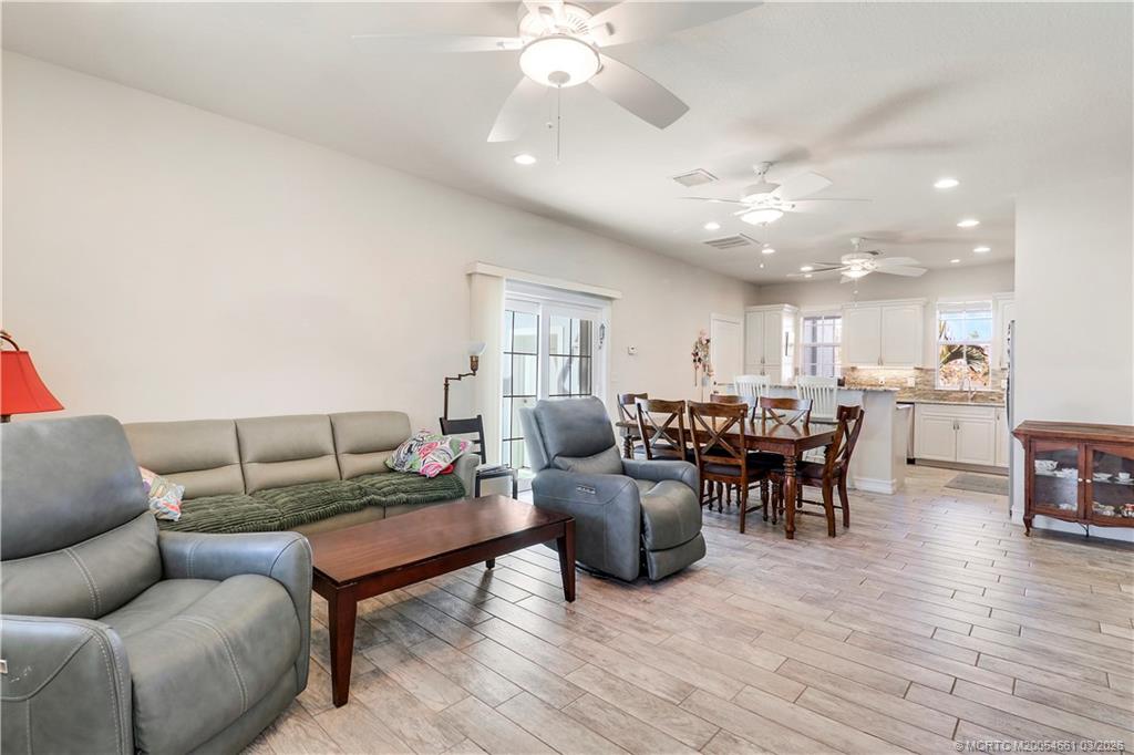 5352 Southeast Nassau Terrace Stuart, FL 34997 - Photo 24 of 53 a living room with furniture a wooden floor and chandelier