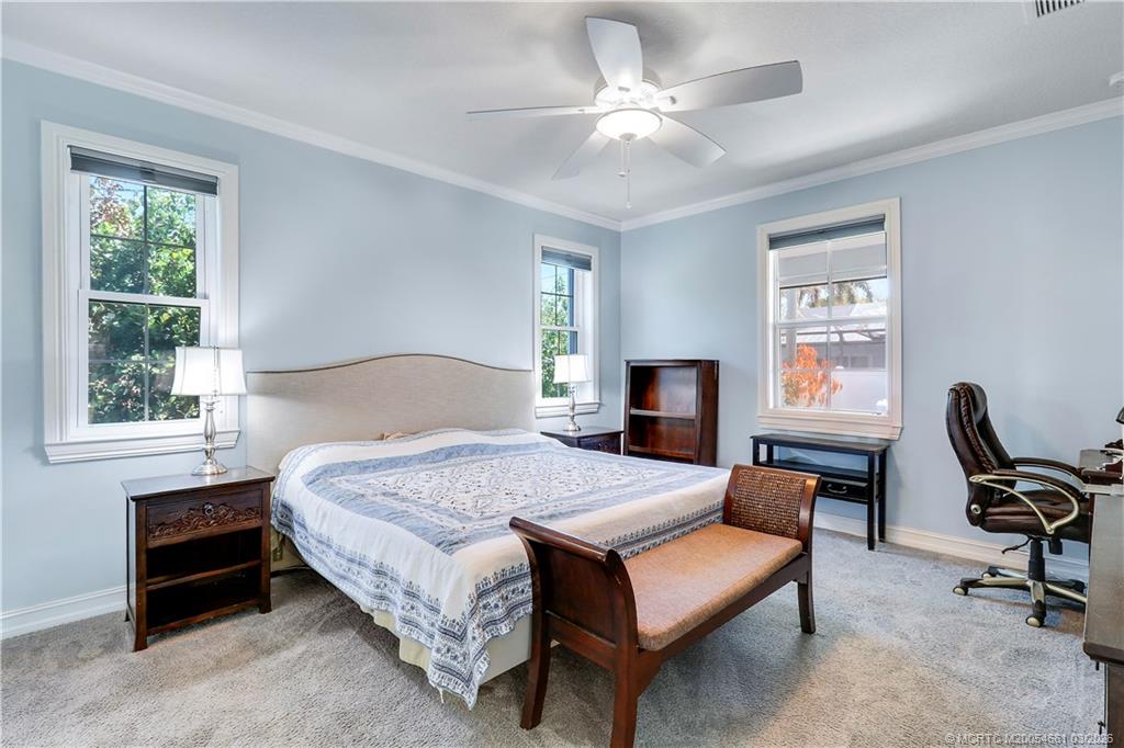5352 Southeast Nassau Terrace Stuart, FL 34997 - Photo 27 of 53 a bedroom with a bed a computer on desk and a dresser next to a window