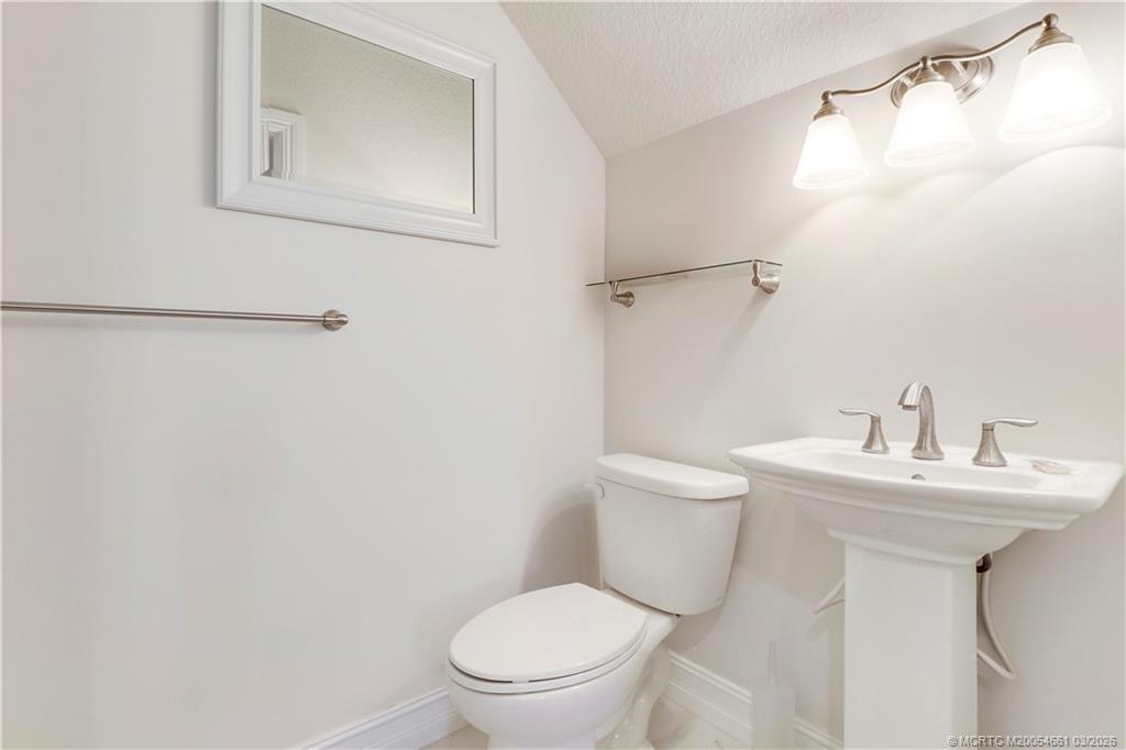 5352 Southeast Nassau Terrace Stuart, FL 34997 - Photo 42 of 53 a bathroom with a toilet sink and mirror